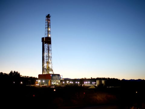 A natural gas drilling rig's lights shimmer in the evening light near Silt, Colo. Methane is the main component of natural gas, and studies show some methane escapes from leaky oil and gas operations.